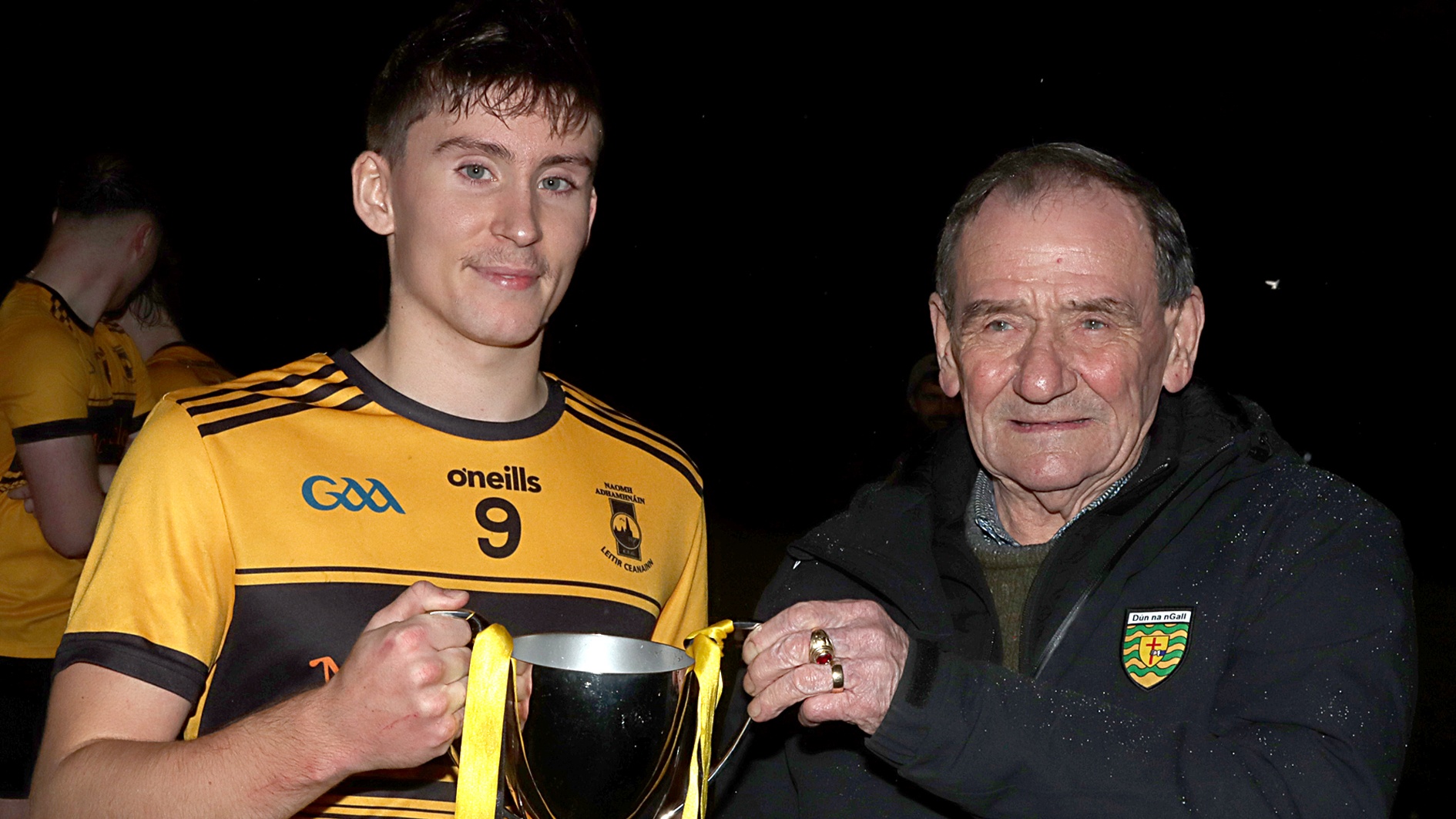 St Eunan's captain Peter Kelly collects the winners cup from Frankie Doherty, Donegal GAA county board.