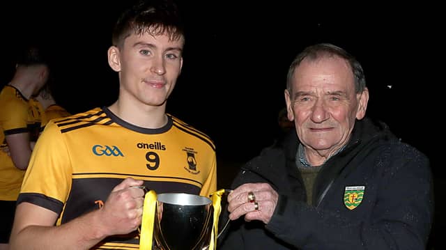 St Eunan's captain Peter Kelly collects the winners cup from Frankie Doherty, Donegal GAA county board.
