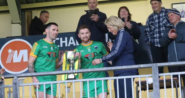 Pauric Ward and Philip Doherty are presented with the cup by Mary Coughlan