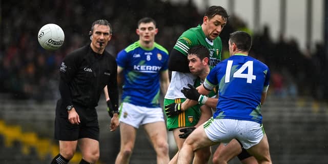 Ryan McHugh of Donegal gets the ball away under pressure from teammate Hugh McFadden and Paul Geaney of Kerry