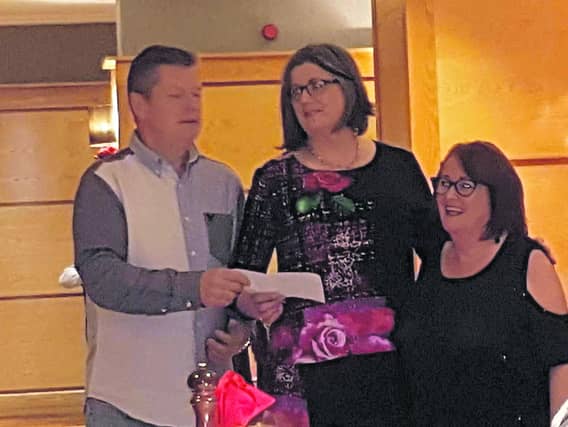 Thomas McGuinness making a presentation to Mary MacCarthy, along with Anne Marie Burke, Secretary.