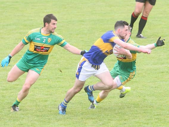 Mark McHugh evades the challenges of Paddy McGrath and Ryan Malley