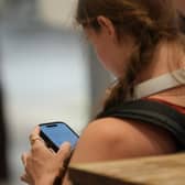 A teenager on her phone; but is she over-16? Police, please!