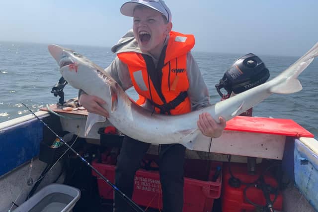 Finn proudly displays the shark he caught in a boat off Moville.
