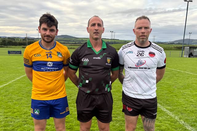 Burt captain Sean McHugh and Red Hughs' Calvin Bradley with match referee Sean McDaid.
