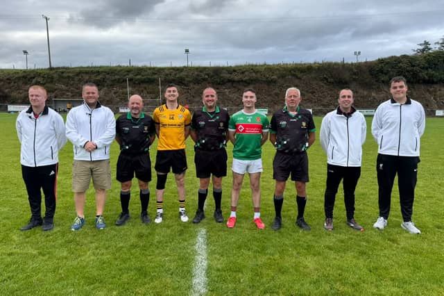 Malin captain Christy McLaughlin with Carn's Darragh Browne and referee Anthony Finn, linesmen Aidan McAleer and Martin McKinley and a bunch of happy umpires from Naomh Colmcille still buzzing after watching their team defeat Naomh Ultan and qualify for the Junior A championship quarter-finals earlier on Saturday afternoon.
