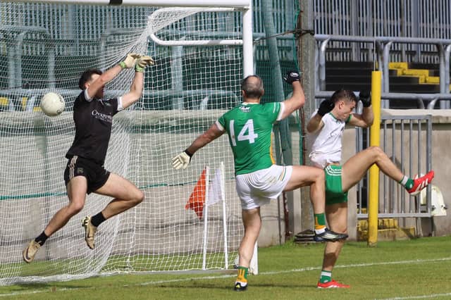 Michael Murphy gets above Joe Boyle to fist to the MacCumhaills net.