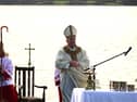 The Bishop in prayer at the scenic altar.