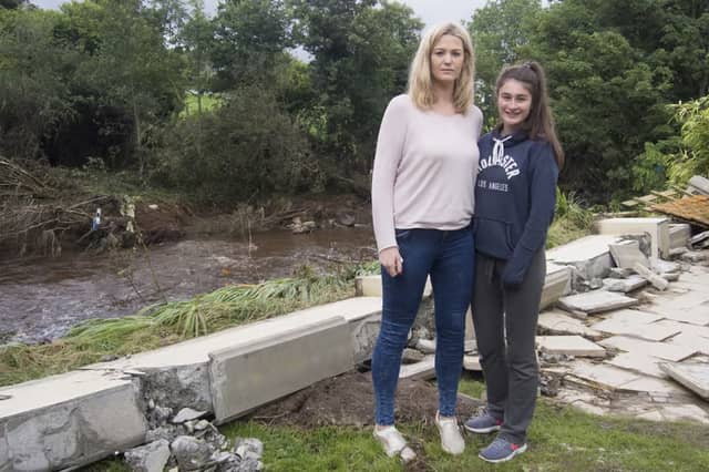 Ciara O'Neill and Molly Dunlop pictured at the back of their flooded Elm Park home in 2017, when the retaining wall collapsed after the nearby Crana River burst its banks. Homes in the Buncrana estate face the dual scourge of mica and flooding.
