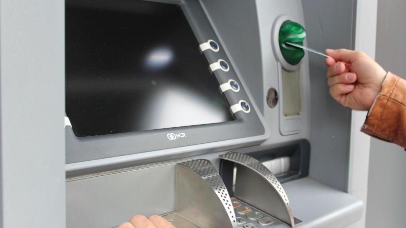 Suspected fraud as two men watch over woman at ATM in Moville