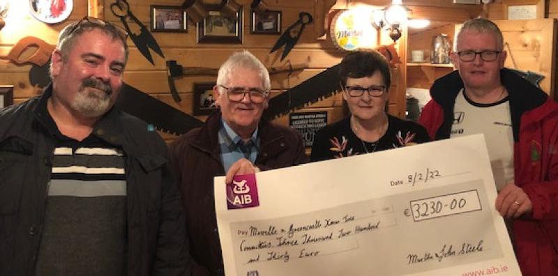 Martha and John Steel presenting the Moville and Greencastle Christmas Tree committees with €1615 each