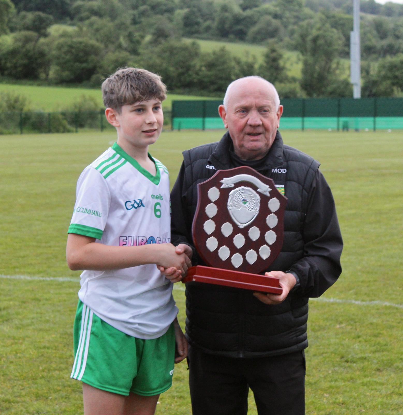 Team captain Eanna Byrne accepts the league trophy from Manus O'Donnell