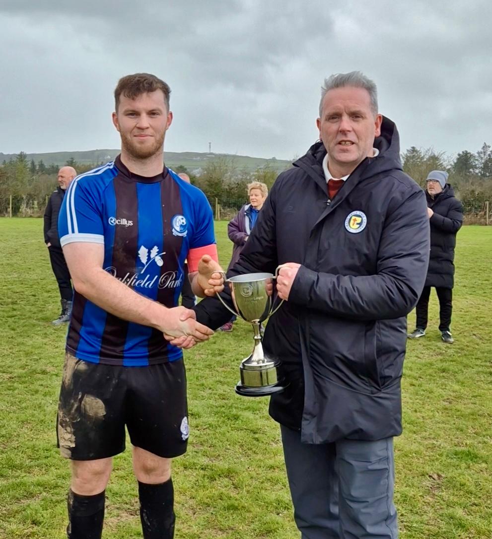 Raphoe Town captain Ryan Murtagh receives the Division 2 title from Liam Porter of the Donegal Junior League